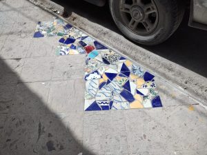 Reparan banquetas con pedacería de mosaico